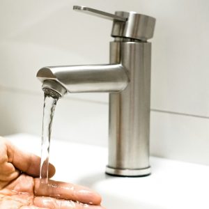 a-person-washing-their-hands-under-a-faucet-kdmhm0mgmec